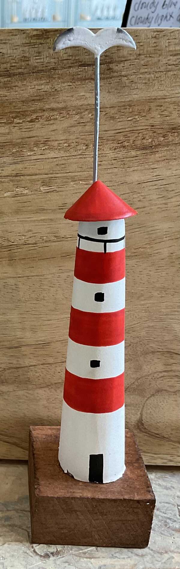 Decorative wooden lighthouse with seagull in red